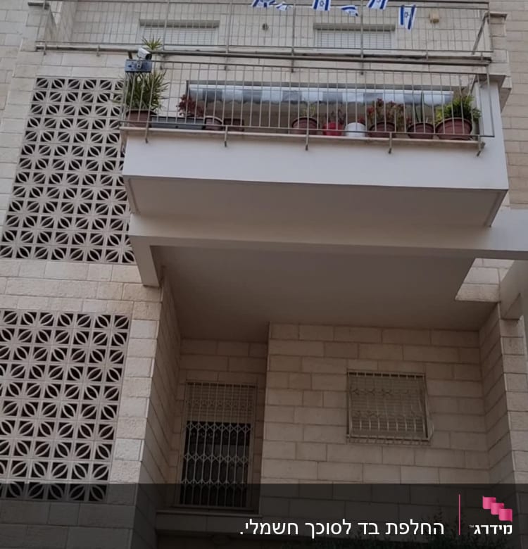 מרפסת עם סוכך מעל עציצים ודגלים